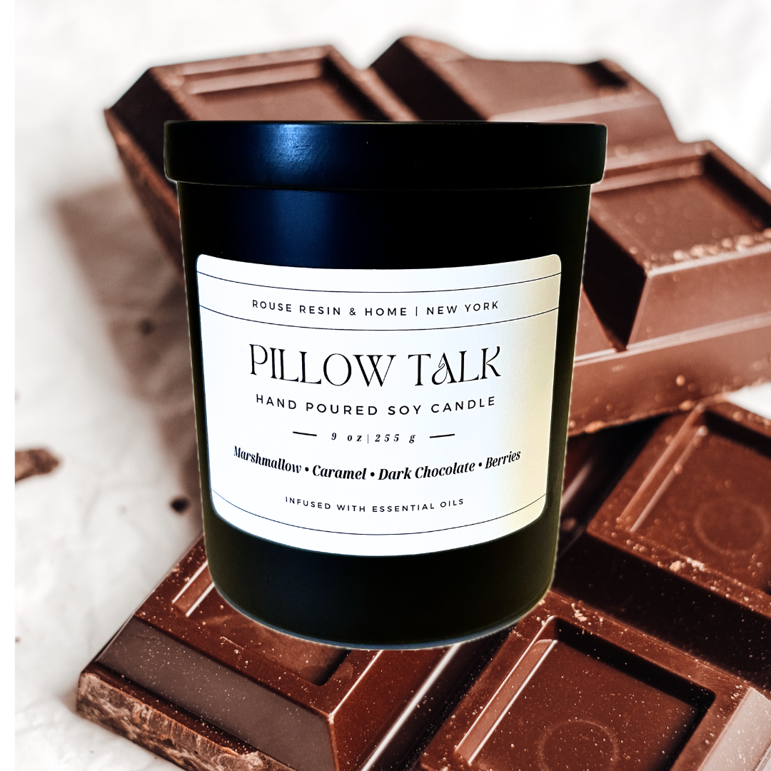A black candle jar with bars of chocolate in the background.