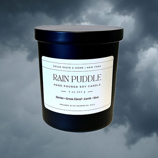 A black candle jar against a storm cloud background.